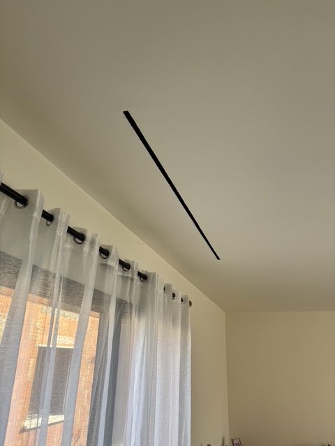 Fente de soufflage linéaire au plafond du salon d'une maison rénovée